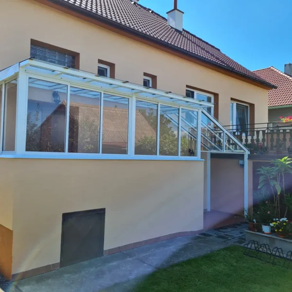 Celkový pohľad na prístrešok nad vchodom v bielej farbe, pohľad z dvora.