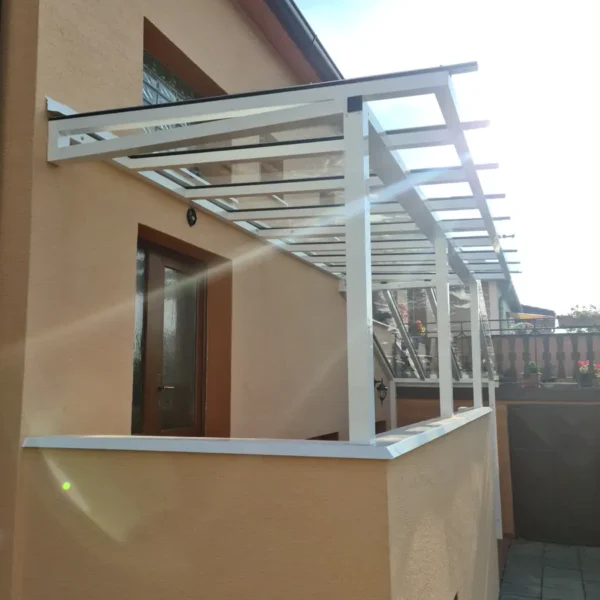Zblízka na prístrešok nad vchodom, zobrazené jednosklo a strecha z VSG skla.