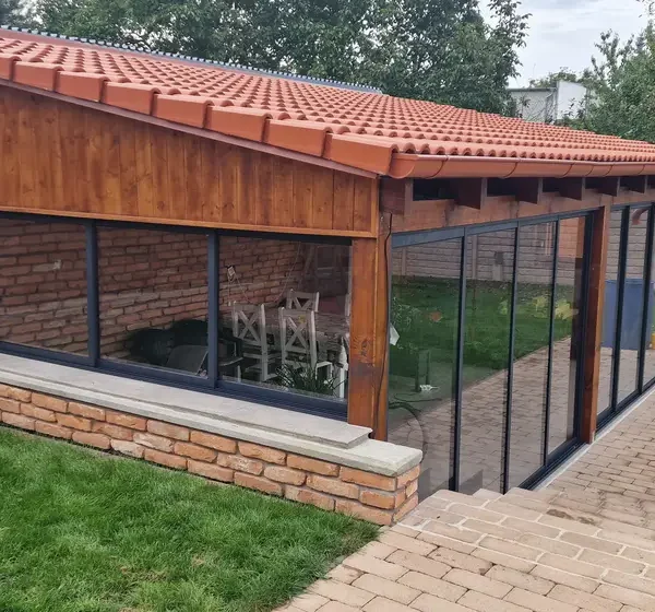 Celkový pohľad na zasklený tehlový altánok s posuvným zasklením v antracitovej farbe v Holíči.