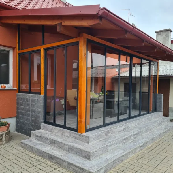 Bočný pohľad na zasklený drevený prístrešok v Holíči, antracitová konštrukcia.