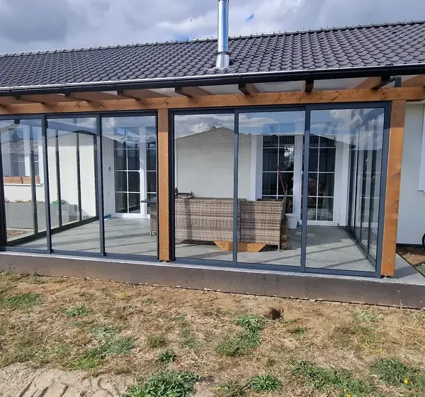 Predný pohľad na zasklenú drevenú pergolu v Holíči v antracitovej farbe.