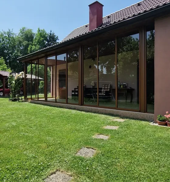Celkový pohľad na zasklenú terasu v hnedej farbe.