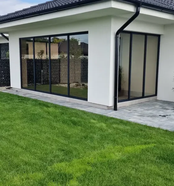 Pohľad z boku na zasklenú terasu rodinného domu v obci Veľký Lég v antracitovej farbe.