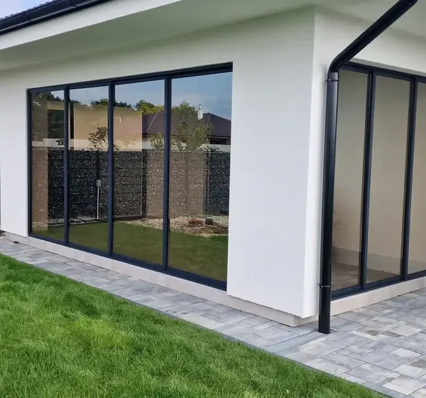 Predný pohľad na zasklenú terasu rodinného domu v obci Veľký Lég v antracitovej farbe.