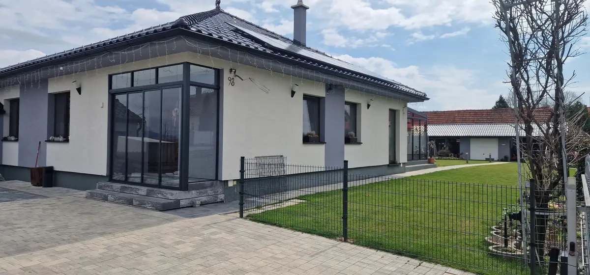Predný pohľad na zasklenie vchodu do rodinného domu v Ležiachove, moderné antracitové prevedenie.
