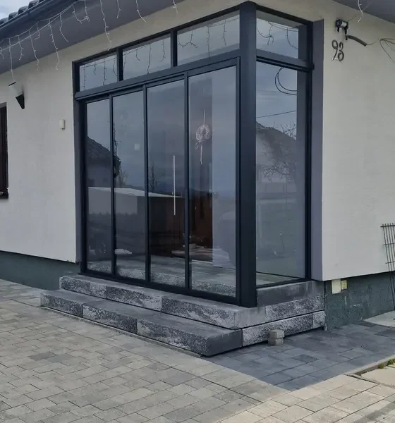 Detailný záber na vchod so zasklením v rodinnom dome v Ležiachove, prevedenie v antracitovej farbe.