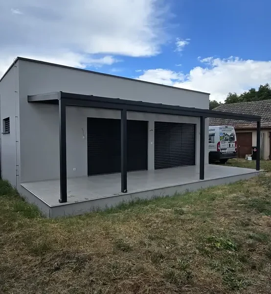 Vonkajší pohľad na hliníkovú pergolu s rozmermi 10 x 3,2 m a moderný dom v Šajdíkových Humenciach, realizovanú v antracitovej farbe RAL 7016.