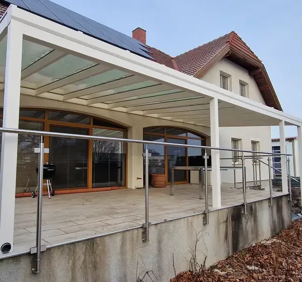 Montáž hliníkovej pergoly 11x4 m na vyvýšenej terase rodinného domu v Hagenbrunne, detail na biele rámy RAL 9003.