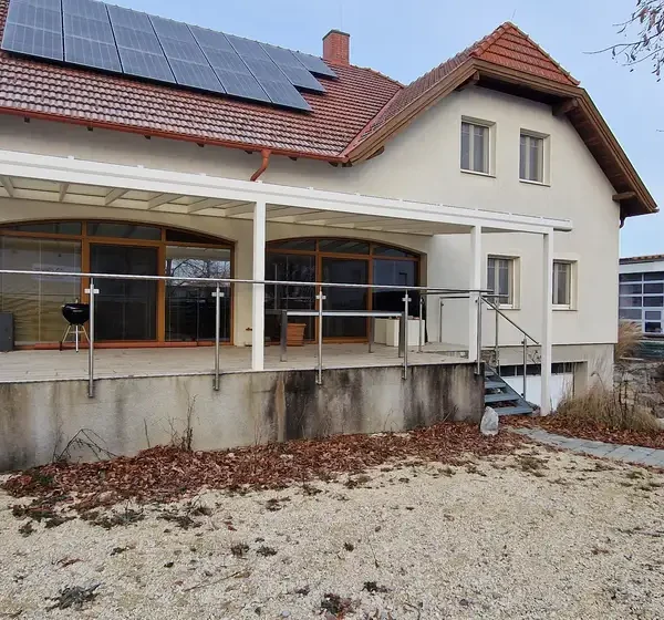 Pohľad zospodu na hliníkovú pergolu 11x4 m na vyvýšenej terase v Hagenbrunne, biela farba RAL 9003.