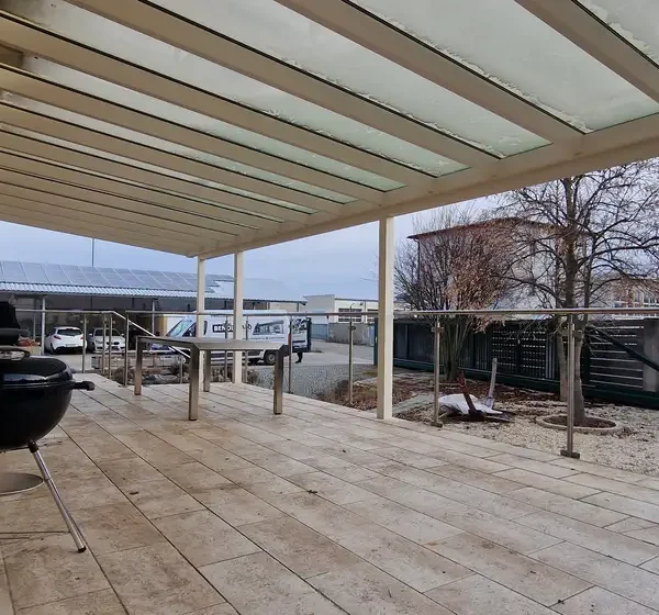 Hliníková pergola 11x4 m na vyvýšenej terase rodinného domu v Hagenbrunne, realizácia v bielej farbe RAL 9003.