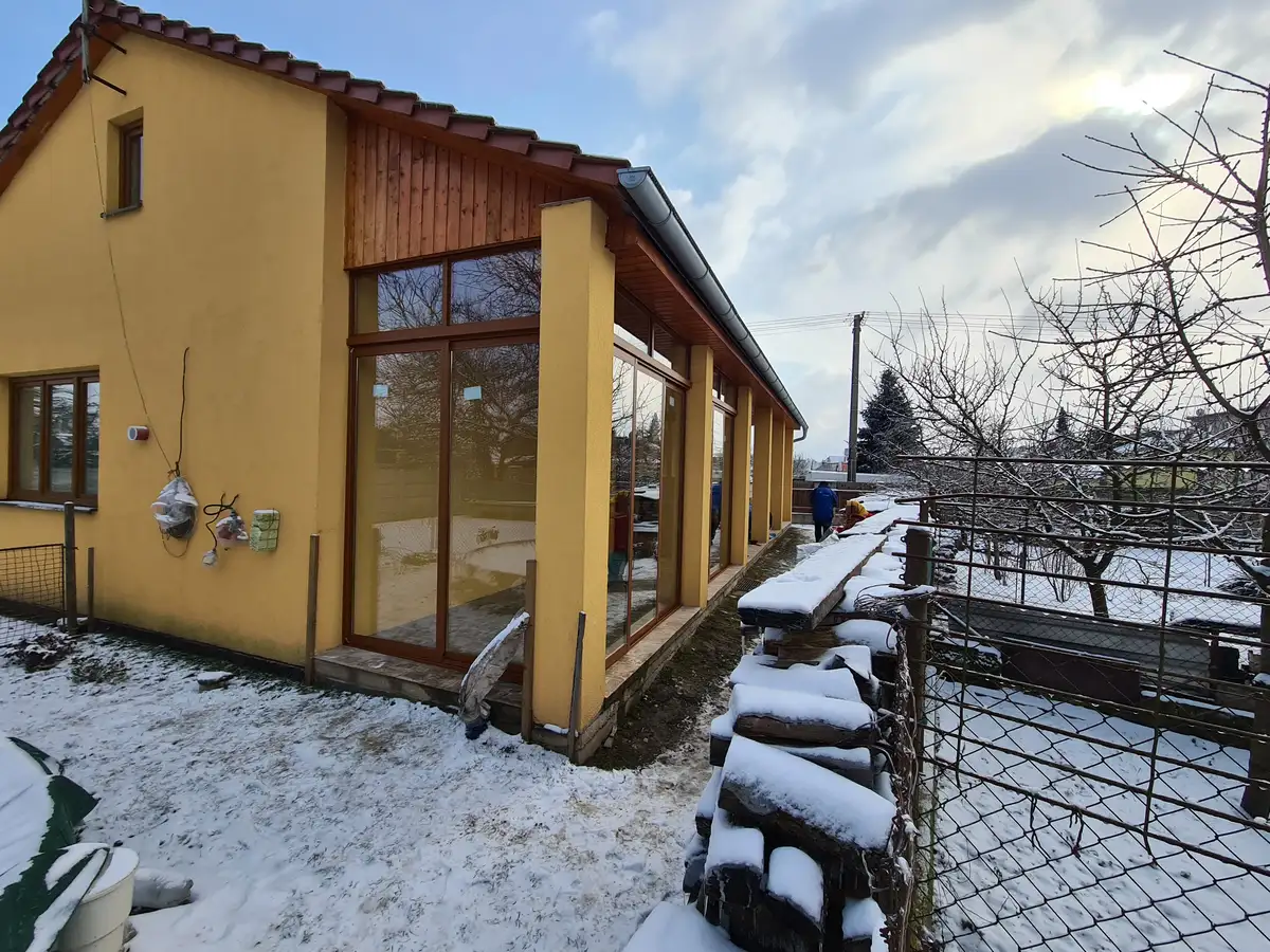 Exteriér zasklenej dlhej terasy s posuvným rámovým systémom RAL 8003 v Břeclavi.