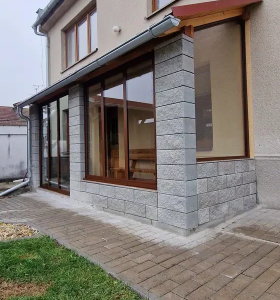 Atypické fixné okno a zasklenie terasy s posuvným hliníkovým systémom v obci Kúty, v tmavohnedej farbe RAL 8017, detail pohľadu z bočnej strany.