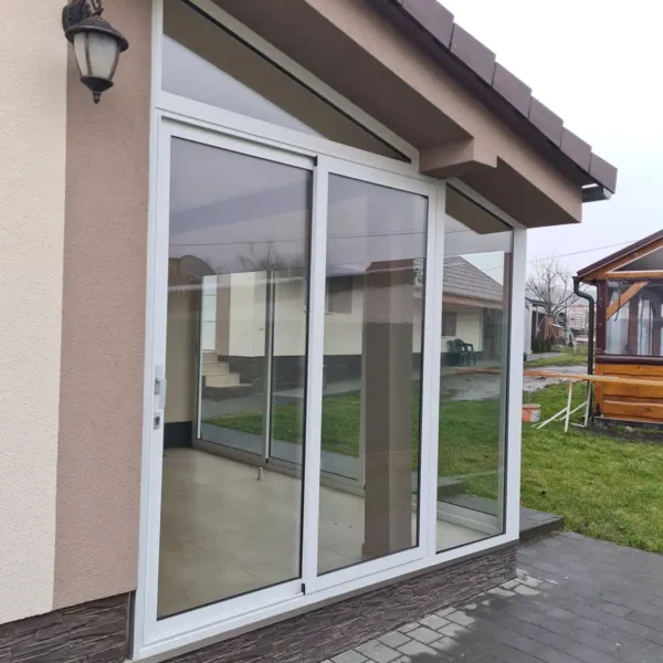 Bočný pohľad na kompletne zasklenú terasu rodinného domu v Gbeloch, využitie bieleho hliníkového systému s izolačným dvojsklom.