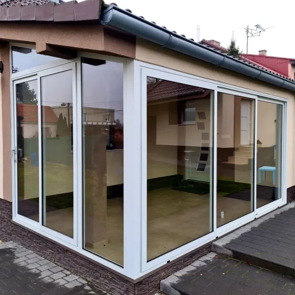 Rohový detail zasklenia terasy rodinného domu v Gbeloch, s dôrazom na čisté línie a biely hliníkový rámový systém.