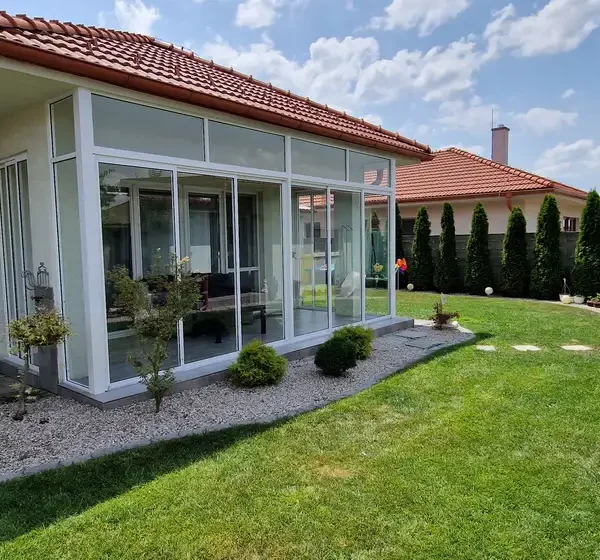 Bočný pohľad na biely posuvný systém zasklenia terasy so svetlíkom v Senici, RAL 9003.