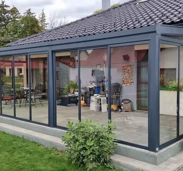 Predný pohľad na zimnú záhradu s posuvným hliníkovým systémom a izolačným dvojsklom, v antracitovej farbe RAL 7016, v obci Ležiachov.