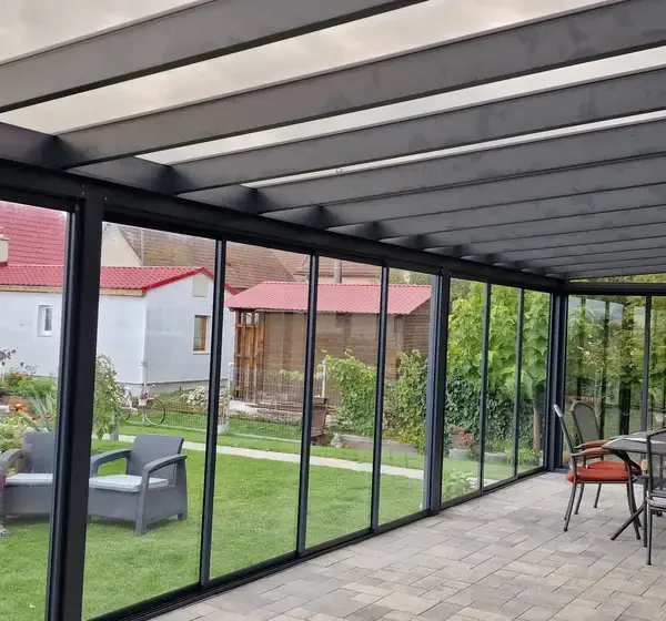 Pohľad z interiéru zimnej záhrady 10x4 m s posuvným hliníkovým systémom a izolačným dvojsklom, antracitová farba RAL 7016, realizácia v Ležiachove.